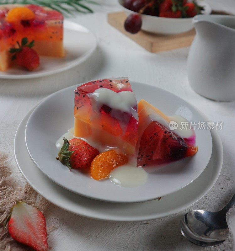 fruit pudding with sliced ​​strawberries and oranges served on a white plate